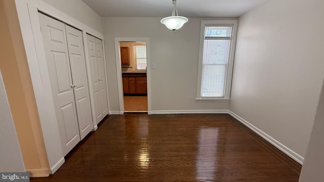 unfurnished dining area with dark hardwood / wood-style floors