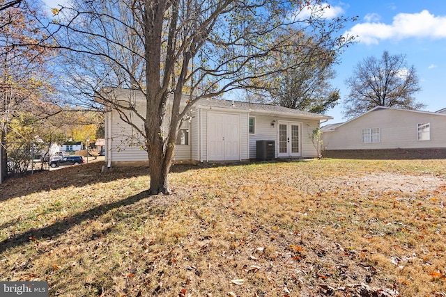 rear view of house featuring central AC, a lawn, and french doors