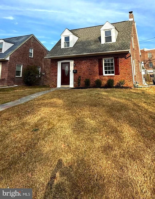 cape cod-style house with a front yard