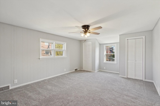 spare room with ceiling fan and light colored carpet