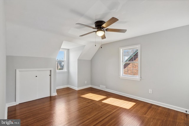 bonus room with vaulted ceiling, dark hardwood / wood-style floors, ceiling fan, and a healthy amount of sunlight