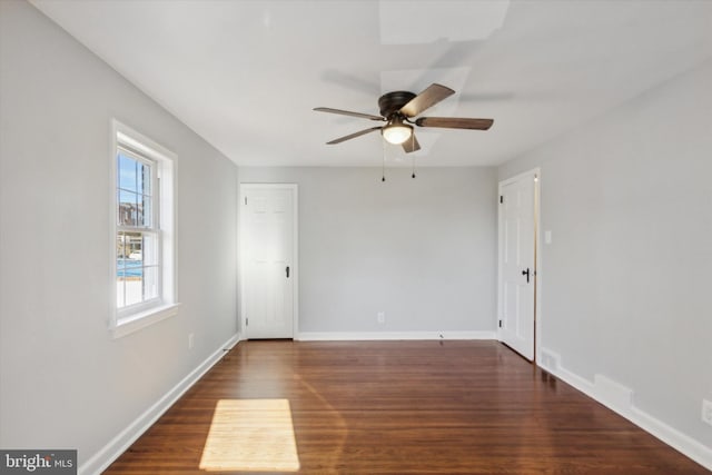 empty room with ceiling fan and dark wood-type flooring