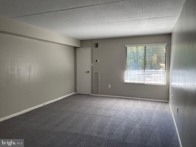 unfurnished room featuring carpet flooring and a textured ceiling