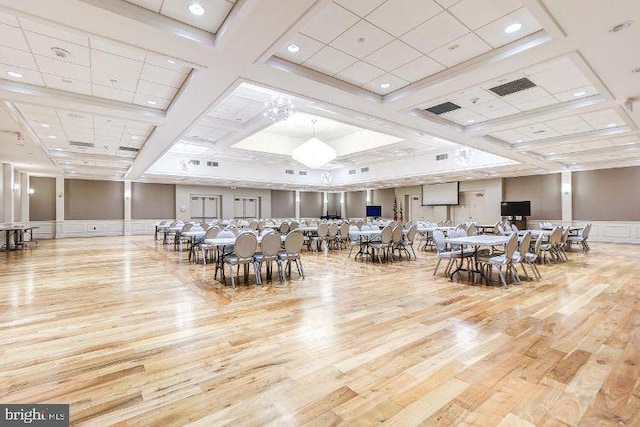 dining room with light hardwood / wood-style floors and coffered ceiling