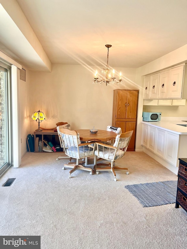 carpeted dining space with plenty of natural light and a chandelier