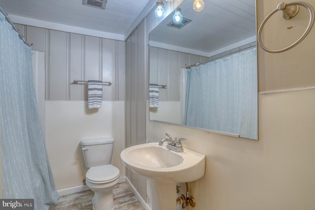 bathroom with walk in shower, hardwood / wood-style floors, and toilet