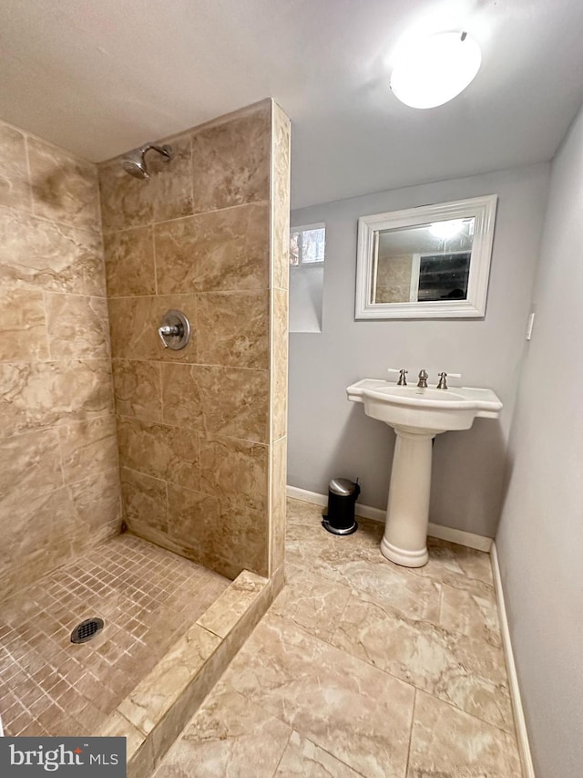 bathroom with sink and a tile shower