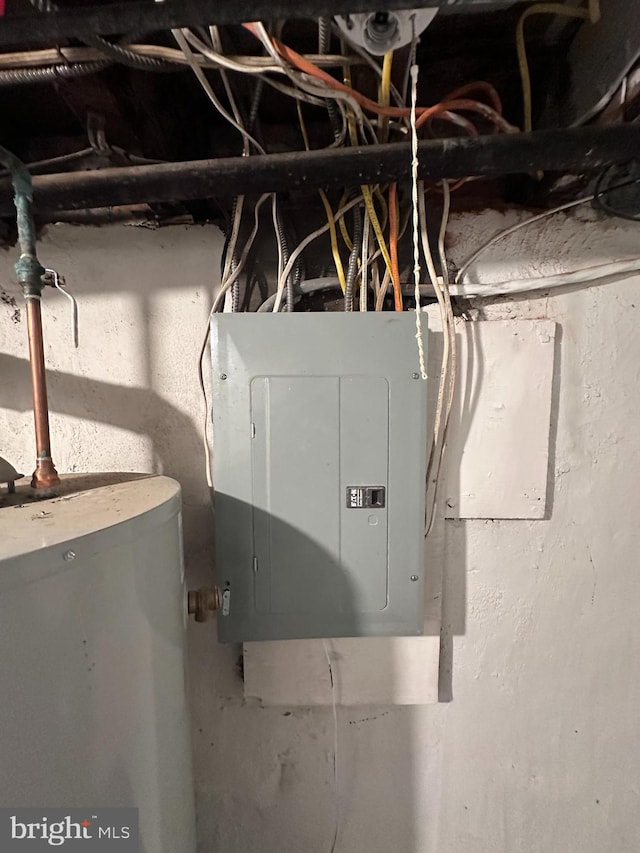 utility room featuring electric panel and water heater