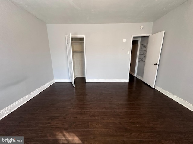 unfurnished room with dark hardwood / wood-style flooring