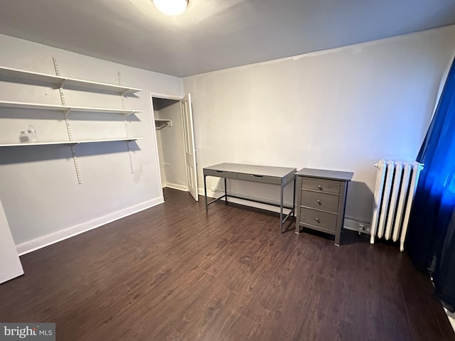 bedroom with dark wood-type flooring and radiator