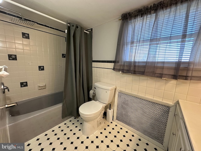 full bathroom featuring vanity, shower / bathtub combination with curtain, tile walls, and toilet