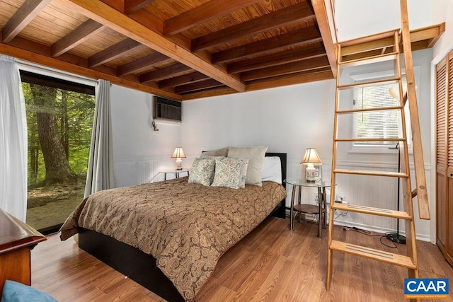 bedroom with light wood-type flooring, beamed ceiling, wooden ceiling, and a closet