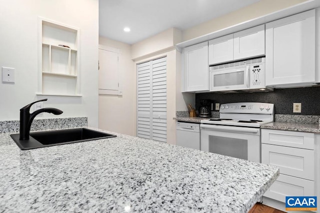 kitchen featuring white cabinetry, sink, and white appliances