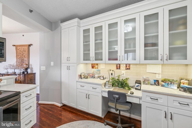 kitchen featuring dark hardwood / wood-style flooring, backsplash, a textured ceiling, stainless steel appliances, and white cabinets