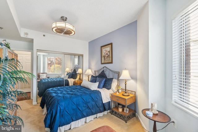 carpeted bedroom featuring multiple windows and a closet