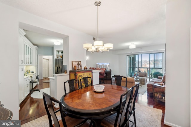 dining area with wood-type flooring and a notable chandelier