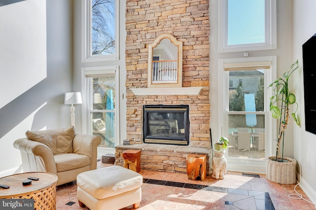 sitting room with a fireplace and a high ceiling