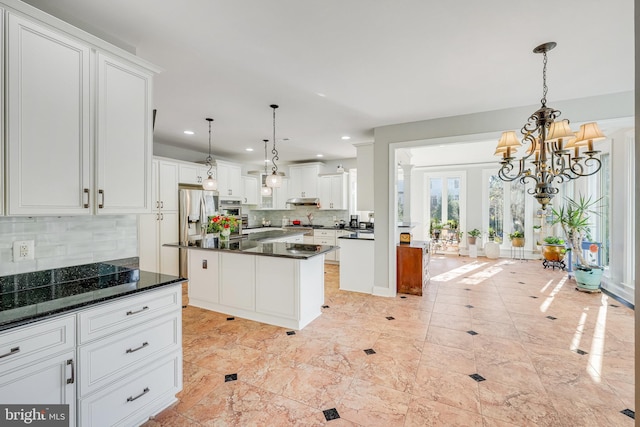 kitchen featuring white cabinets, decorative light fixtures, a center island, and decorative backsplash