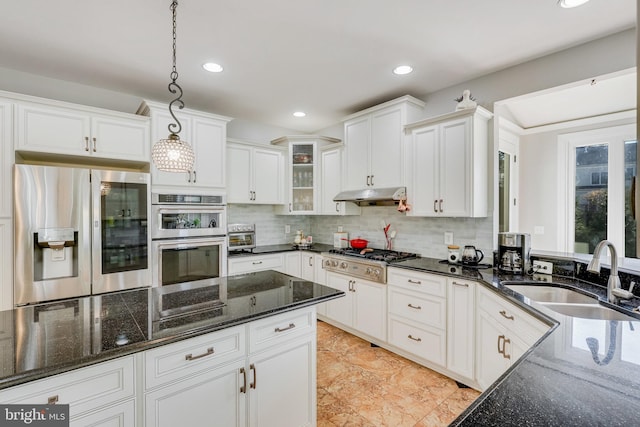 kitchen featuring white cabinetry, sink, hanging light fixtures, backsplash, and appliances with stainless steel finishes