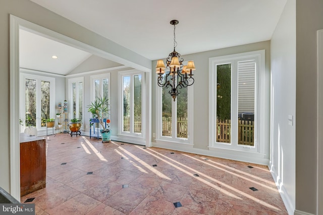 unfurnished dining area featuring a chandelier, french doors, and lofted ceiling