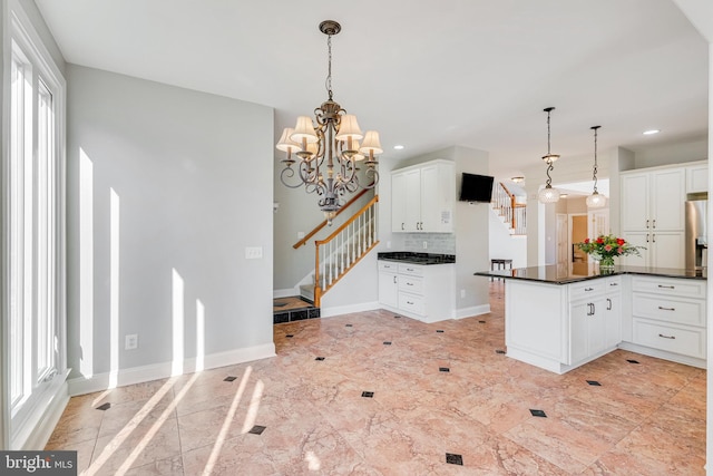 kitchen featuring decorative light fixtures, white cabinetry, and a wealth of natural light