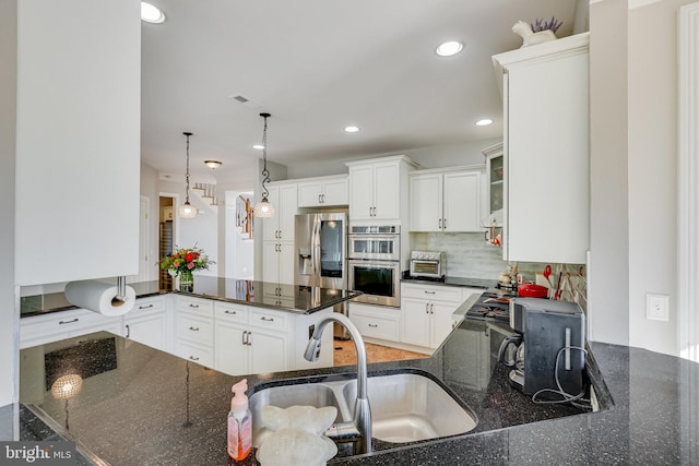 kitchen featuring dark stone counters, white cabinetry, and stainless steel appliances