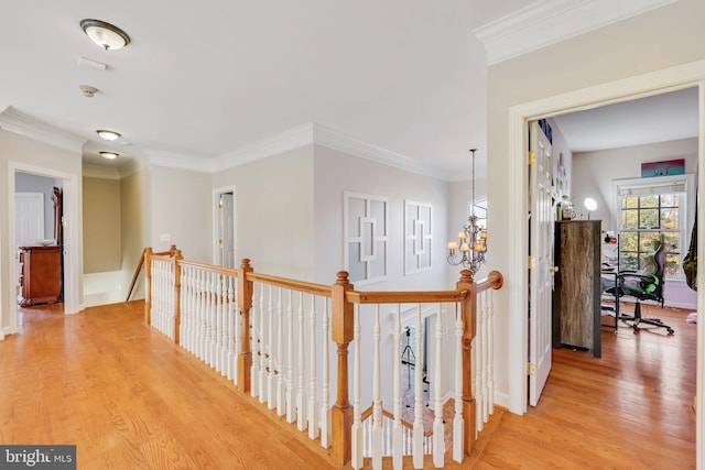 hall featuring a chandelier, light hardwood / wood-style floors, and crown molding