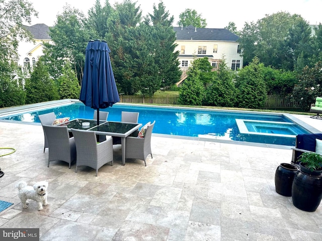 view of swimming pool featuring an in ground hot tub and a patio