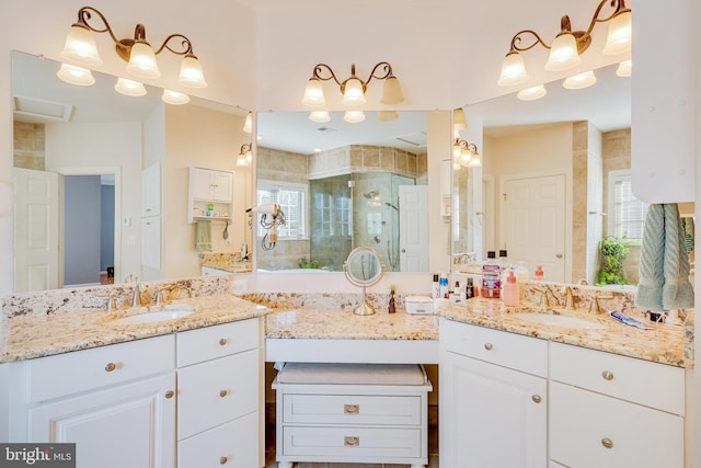 bathroom featuring a shower with door, vanity, and a healthy amount of sunlight