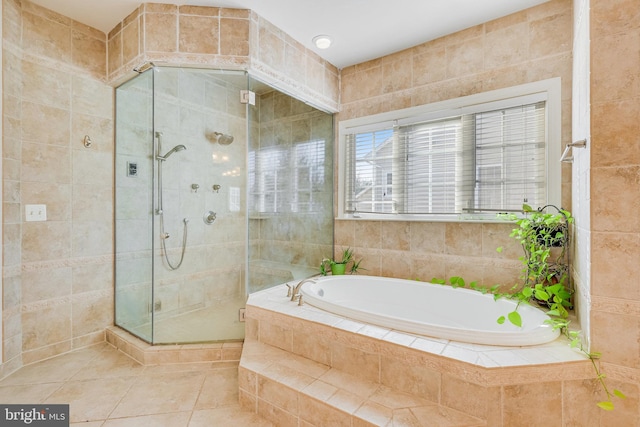 bathroom featuring tile patterned flooring, plus walk in shower, and tile walls