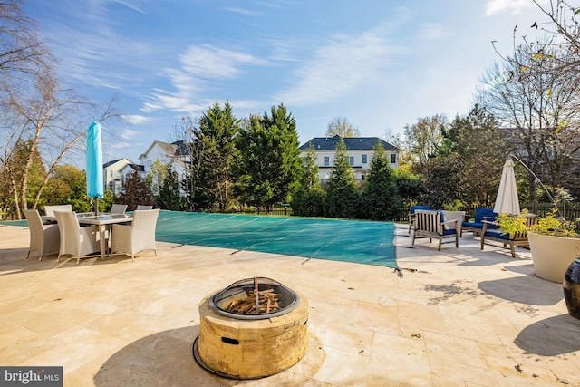 view of pool with an outdoor fire pit and a patio area