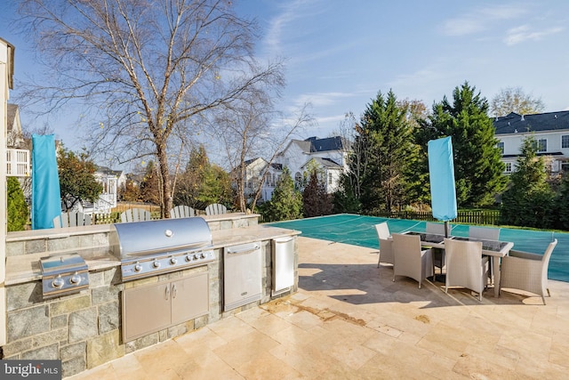 view of pool with a patio, an outdoor kitchen, and area for grilling