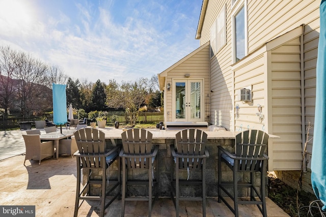 view of patio / terrace featuring a bar and french doors