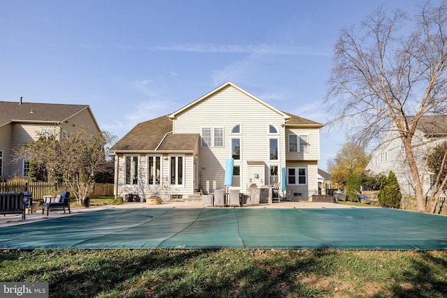 rear view of property with a patio area and a covered pool