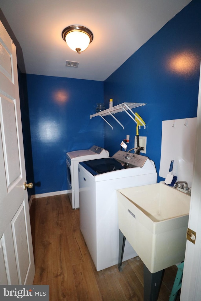 laundry room with dark wood-type flooring, sink, and washing machine and clothes dryer