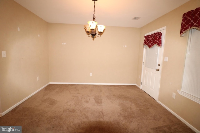 unfurnished room featuring an inviting chandelier and carpet