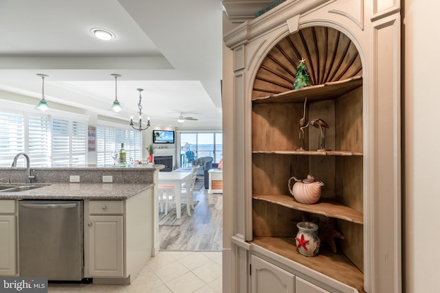 kitchen featuring ceiling fan with notable chandelier, sink, hanging light fixtures, stainless steel dishwasher, and light hardwood / wood-style floors