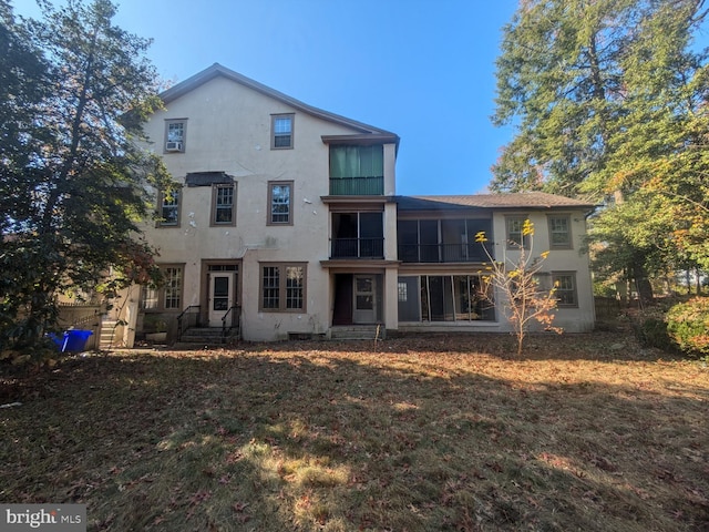 back of property featuring a sunroom and a yard