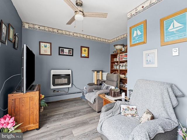 living area featuring ceiling fan, wood-type flooring, baseboard heating, and heating unit