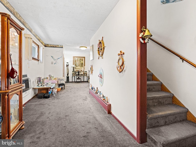 hall with a textured ceiling and carpet floors