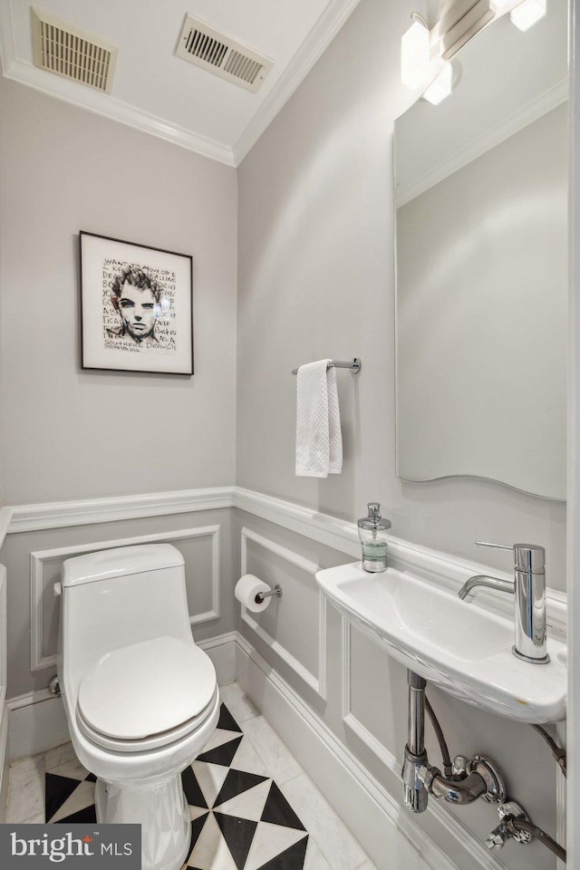 bathroom featuring crown molding, tile patterned flooring, and toilet