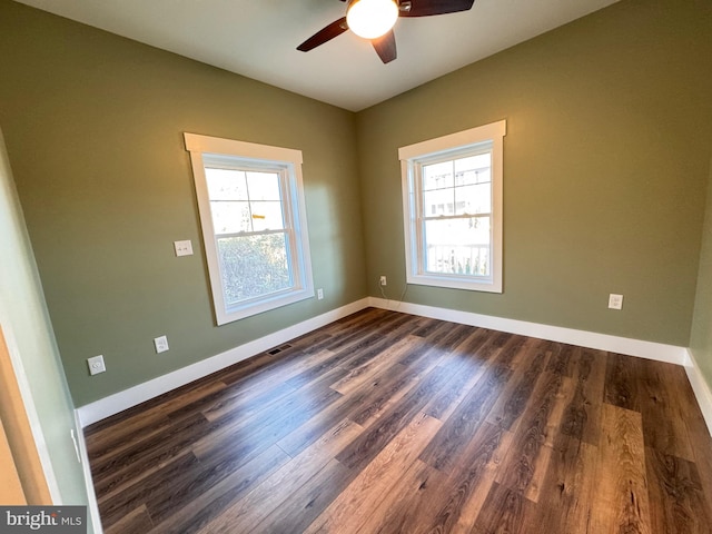 spare room featuring a wealth of natural light, dark hardwood / wood-style floors, and ceiling fan