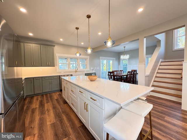 kitchen with dark wood-type flooring, pendant lighting, a healthy amount of sunlight, and a center island