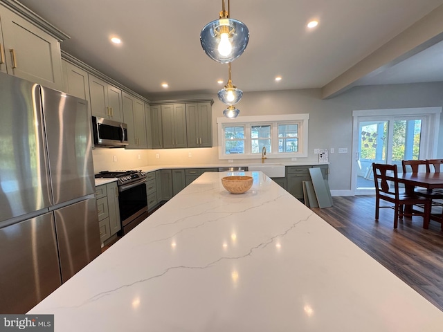 kitchen with gray cabinets, dark wood-type flooring, appliances with stainless steel finishes, and hanging light fixtures