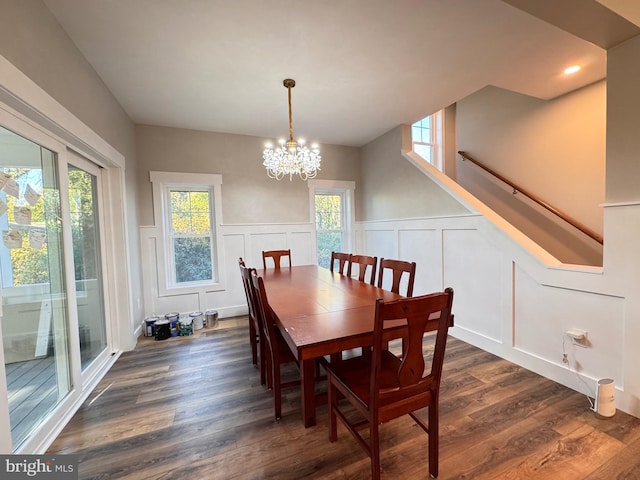 dining room featuring plenty of natural light, dark wood-type flooring, and an inviting chandelier