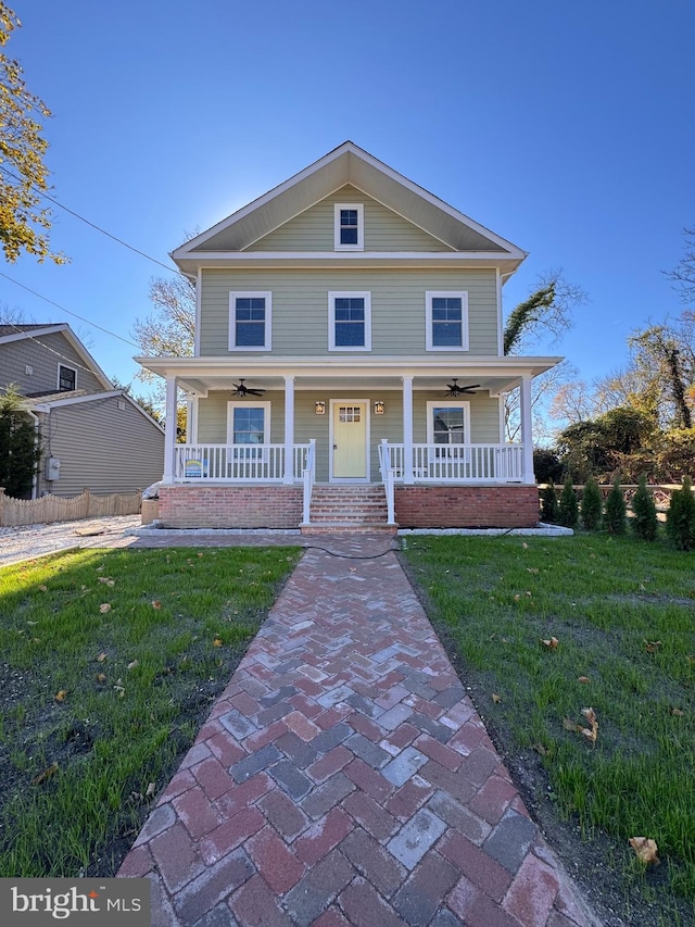 view of front of home with covered porch, ceiling fan, and a front lawn