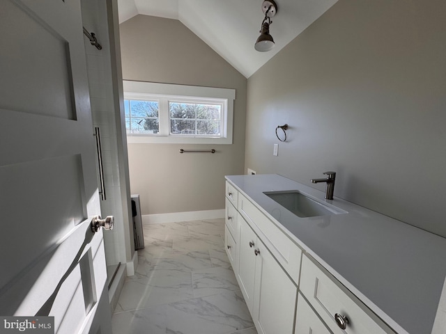 bathroom featuring a shower with door, vanity, and lofted ceiling