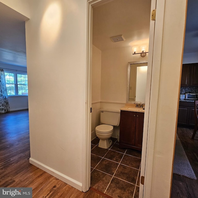 bathroom featuring toilet, vanity, and hardwood / wood-style floors