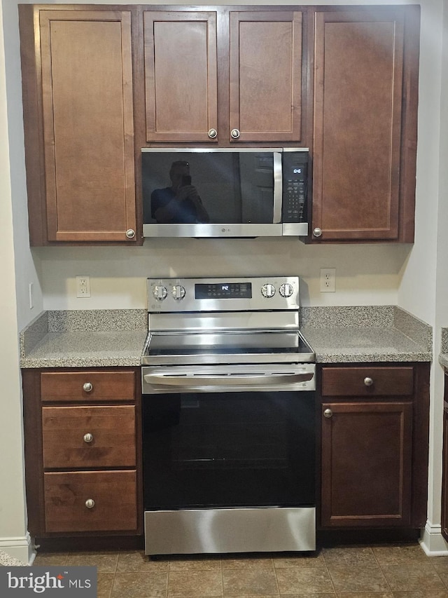 3000 Fountainview Cir Unit 201, Newark, DE 19713 - kitchen featuring stainless steel appliances, light countertops, tile patterned flooring, and dark brown cabinetry