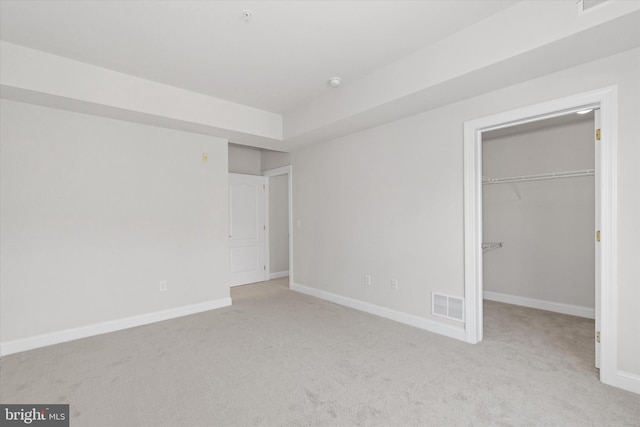 unfurnished bedroom featuring a closet and light carpet